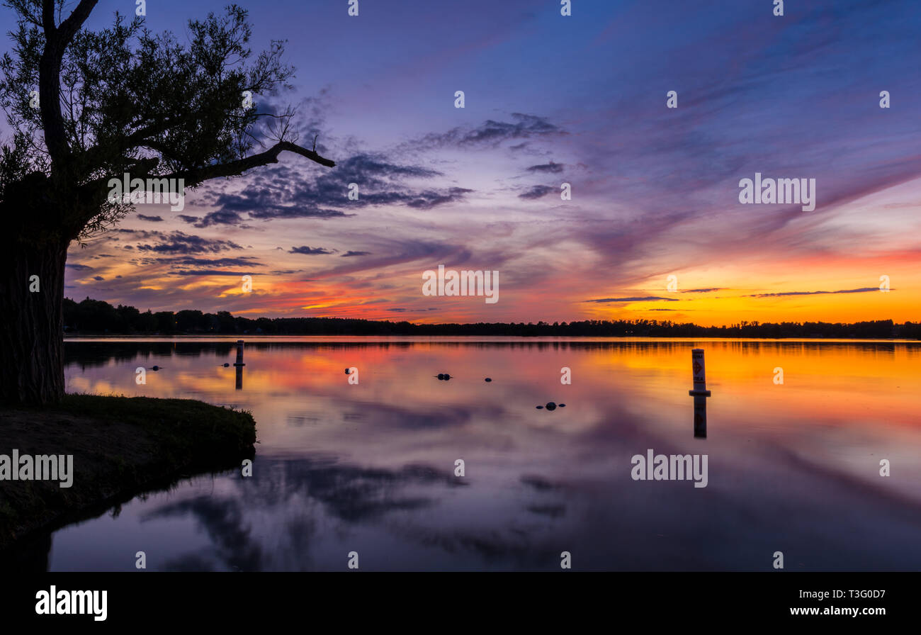Cottage lake sunset with gorgeous pink,blue,magenta and orange sky on a windless day Stock Photo