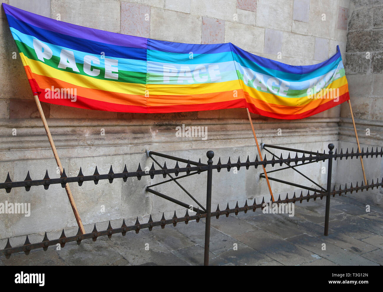 rainbow peace flag during a demonstration of Italian pacifists in an italian city behind grates Stock Photo