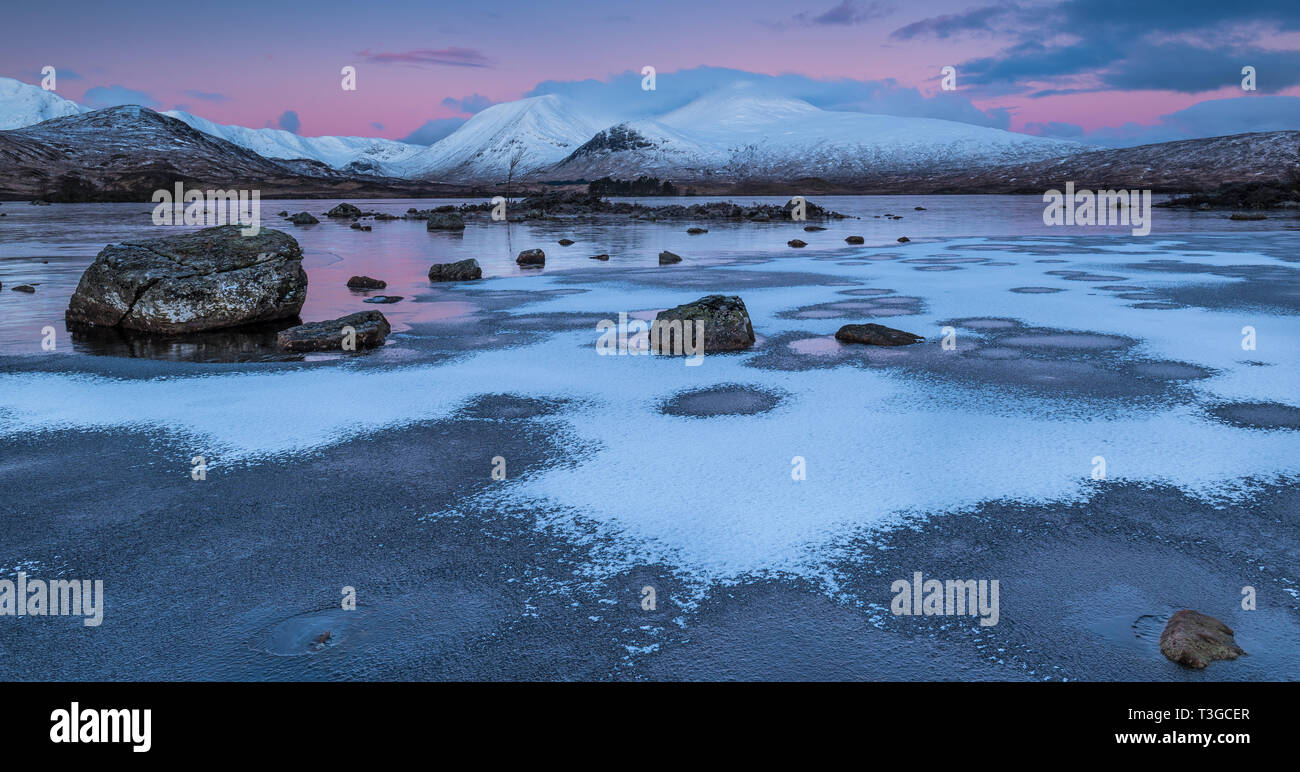 Sunrise over a frozen Lochan na h-achlaise on Rannoch Moor near the enterance to Glencoe in the Scottish Highlands Stock Photo