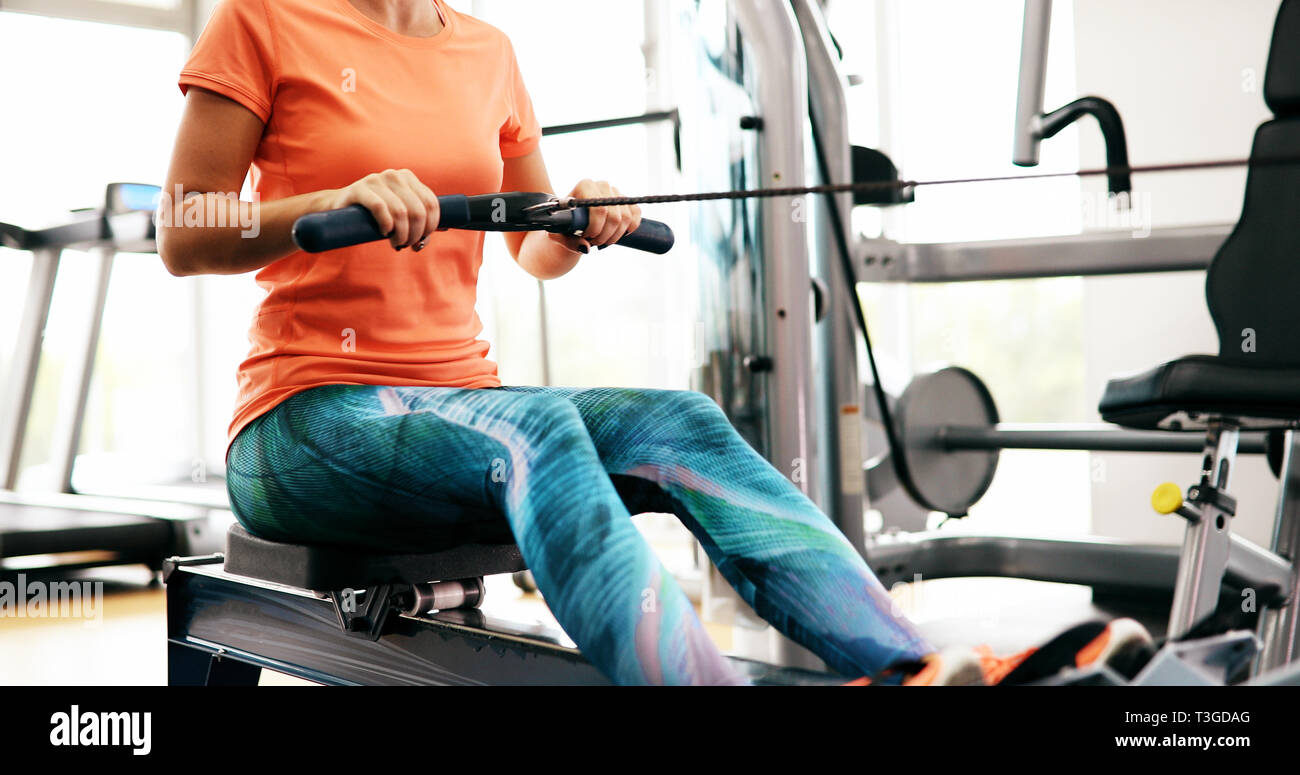 Workout woman cross training exercising cardio using rowing machine Stock Photo