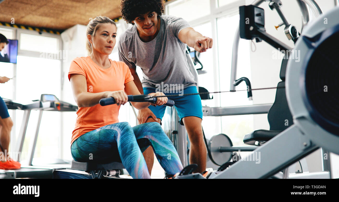 Young beautiful woman doing exercises with personal trainer Stock Photo