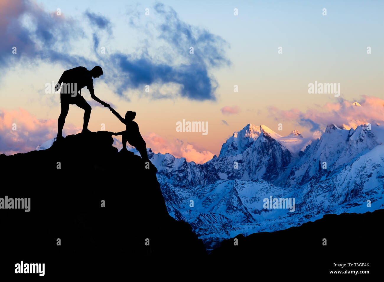 Teamwork couple helping hand, trust in mountains. Team of climbers man and woman hiking, help each other on top of mountain, climbing together, inspir Stock Photo