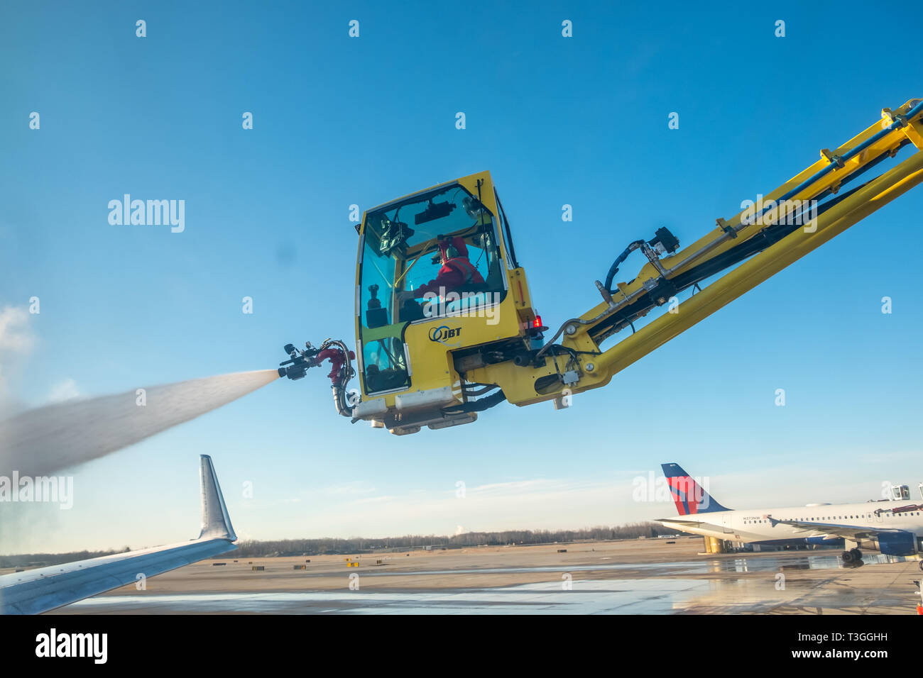 Jet wing being de-iced. Detroit Metro Airport (DTW), USA. Stock Photo