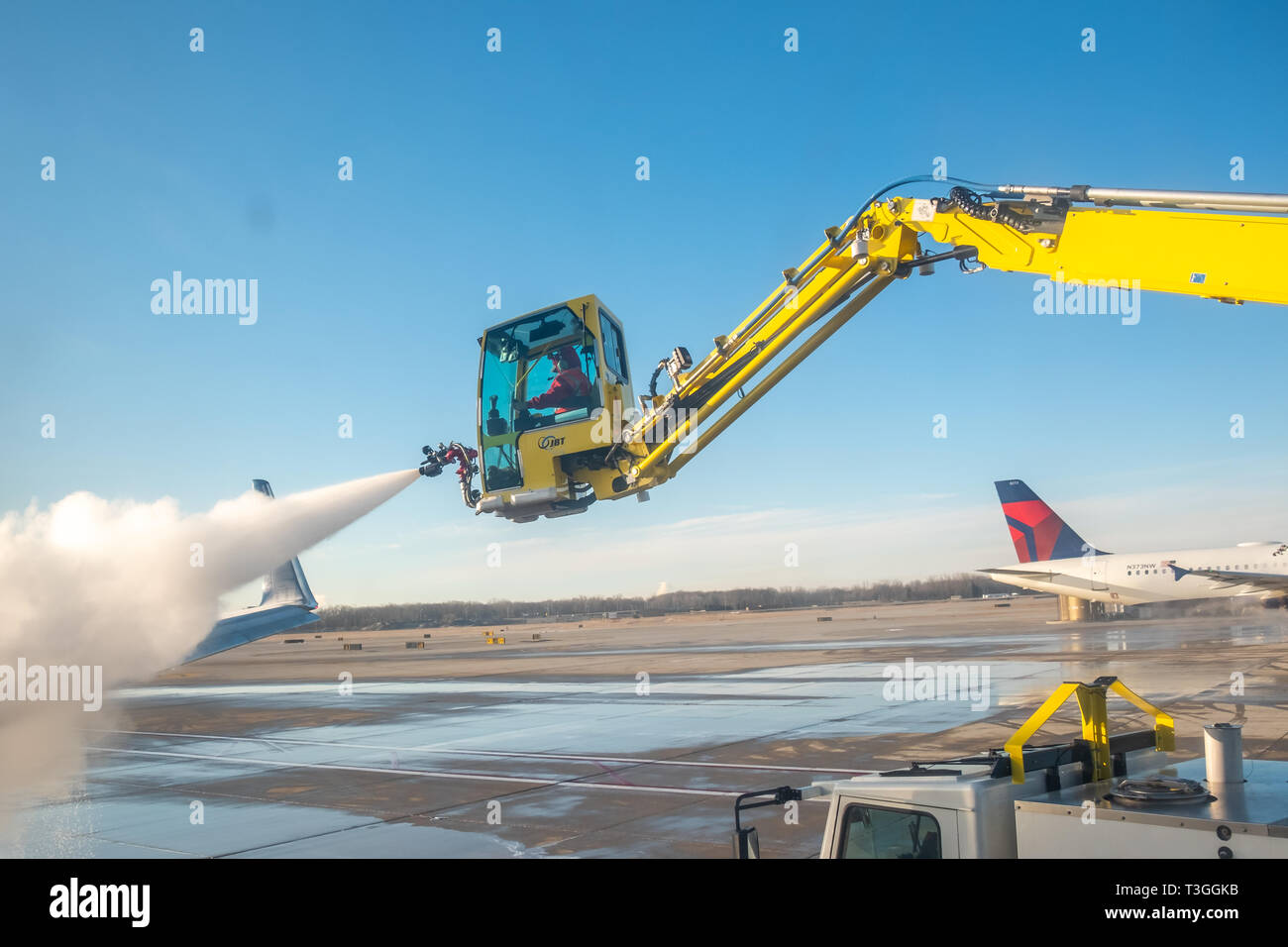 Jet wing being de-iced. Detroit Metro Airport (DTW), USA. Stock Photo
