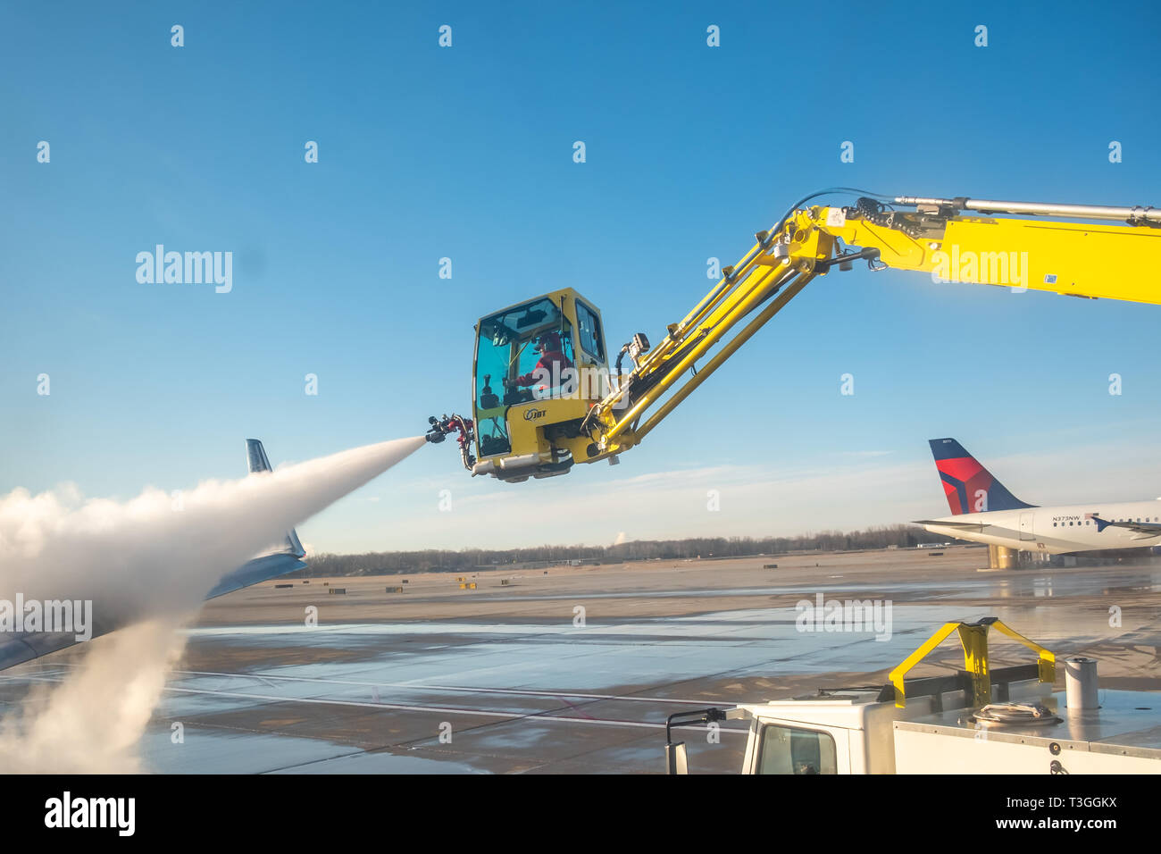 Jet wing being de-iced. Detroit Metro Airport (DTW), USA. Stock Photo