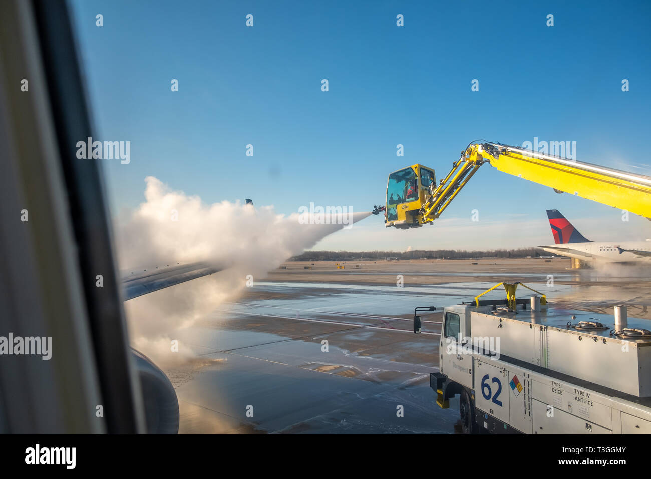 Jet wing being de-iced. Detroit Metro Airport (DTW), USA. Stock Photo