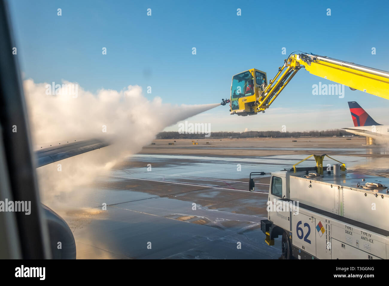 Jet wing being de-iced. Detroit Metro Airport (DTW), USA. Stock Photo