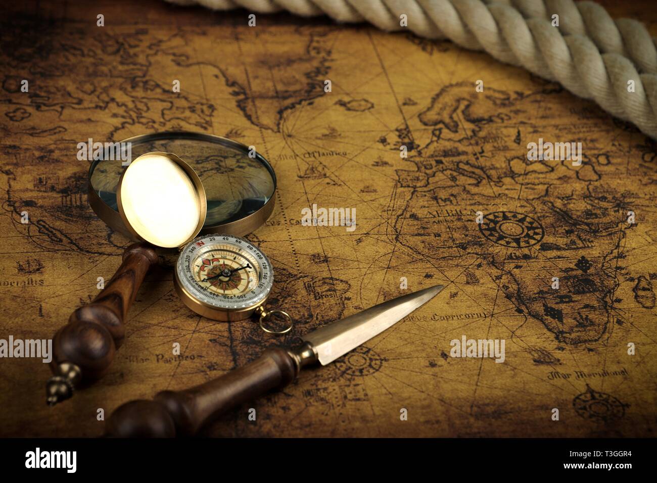 Vintage Compass and magnifying glass lies on an ancient world map ...
