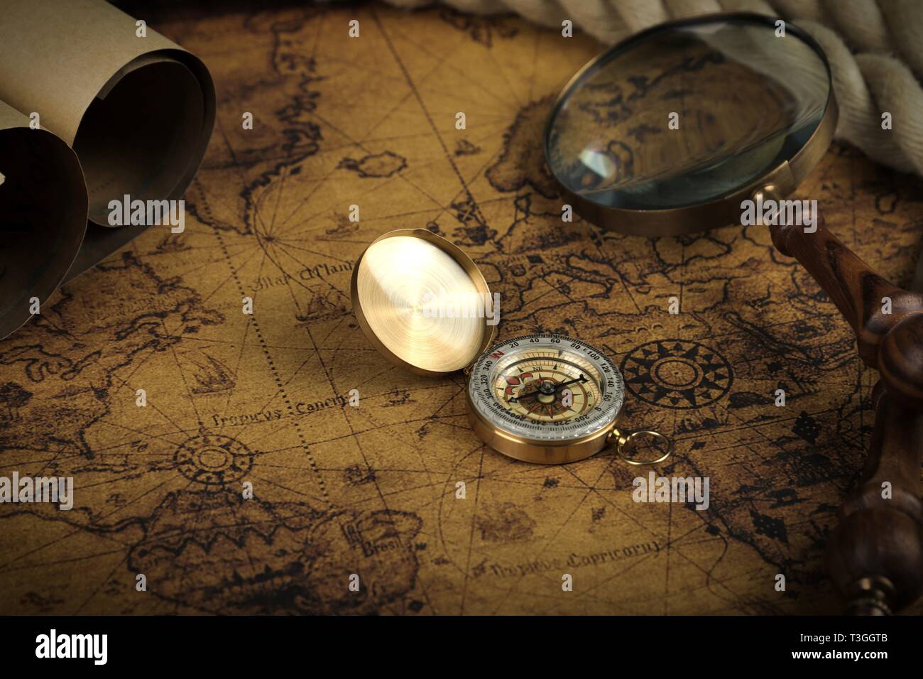 Vintage Compass and magnifying glass lies on an ancient world map ...