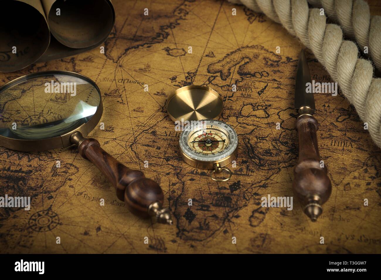 Vintage Compass and magnifying glass lies on an ancient world map ...