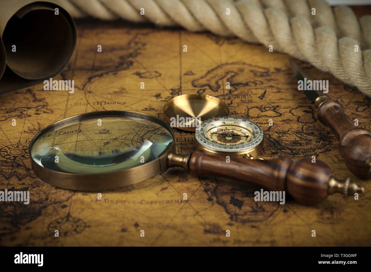 Vintage Compass and magnifying glass lies on an ancient world map ...