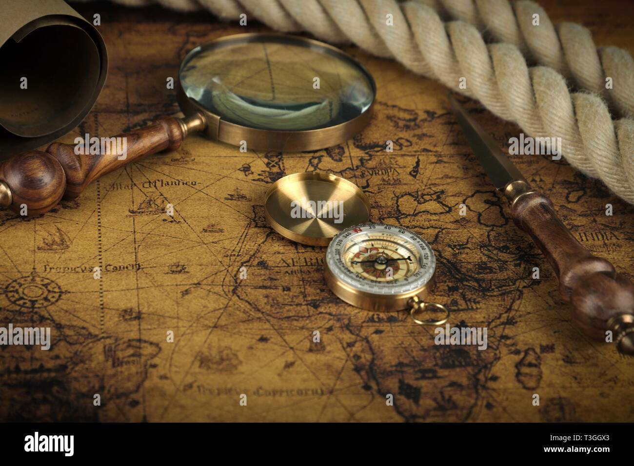 Vintage Compass and magnifying glass lies on an ancient world map ...