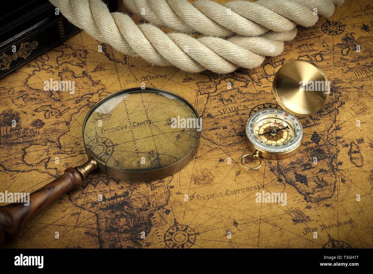 Vintage Compass and magnifying glass lies on an ancient world map ...