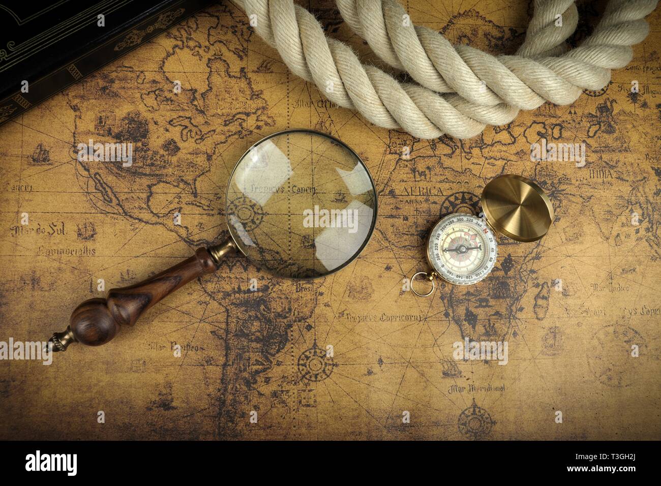 Vintage Compass and magnifying glass lies on an ancient world map ...