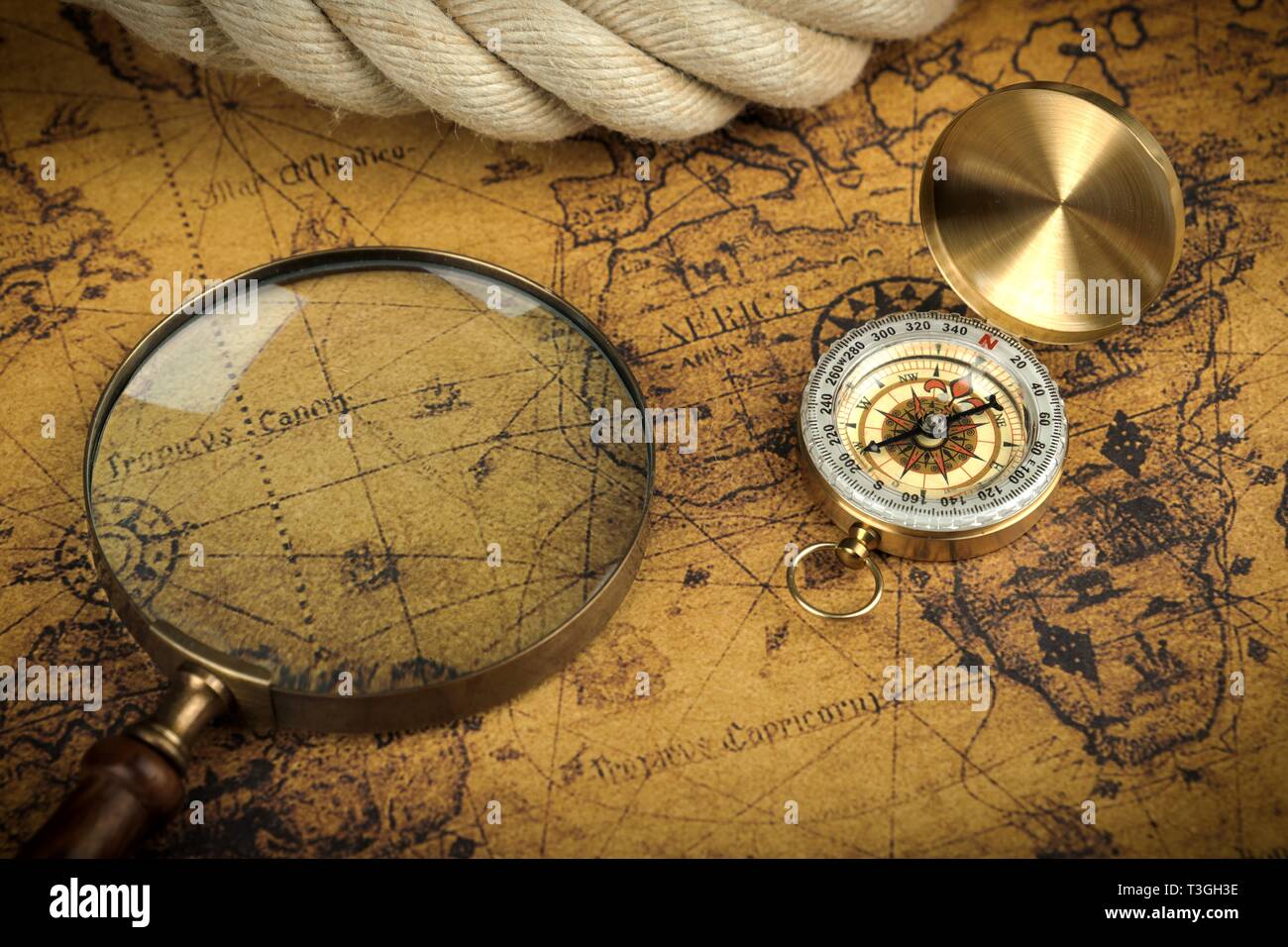 Vintage Compass and magnifying glass lies on an ancient world map ...