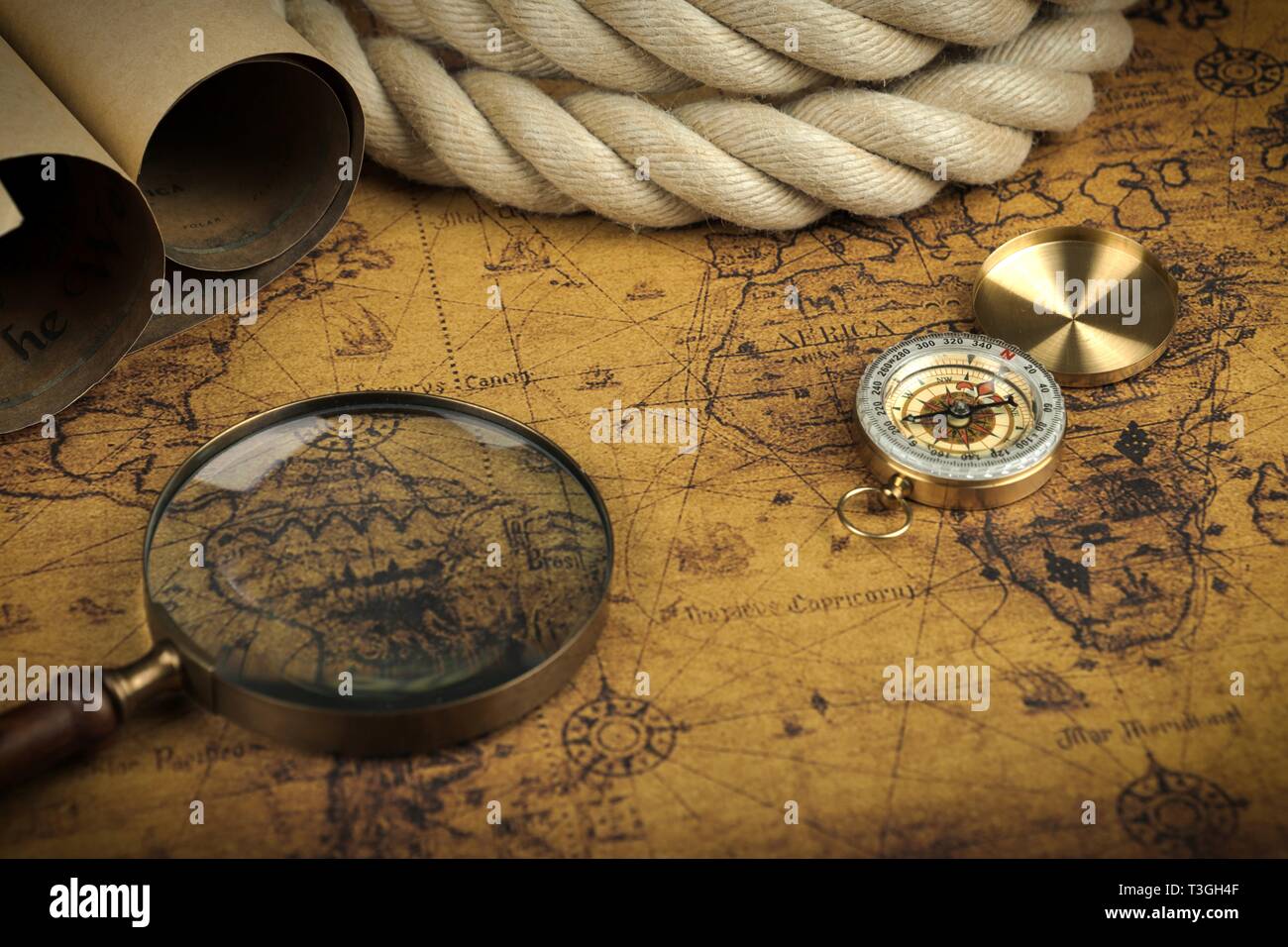 Vintage Compass and magnifying glass lies on an ancient world map ...