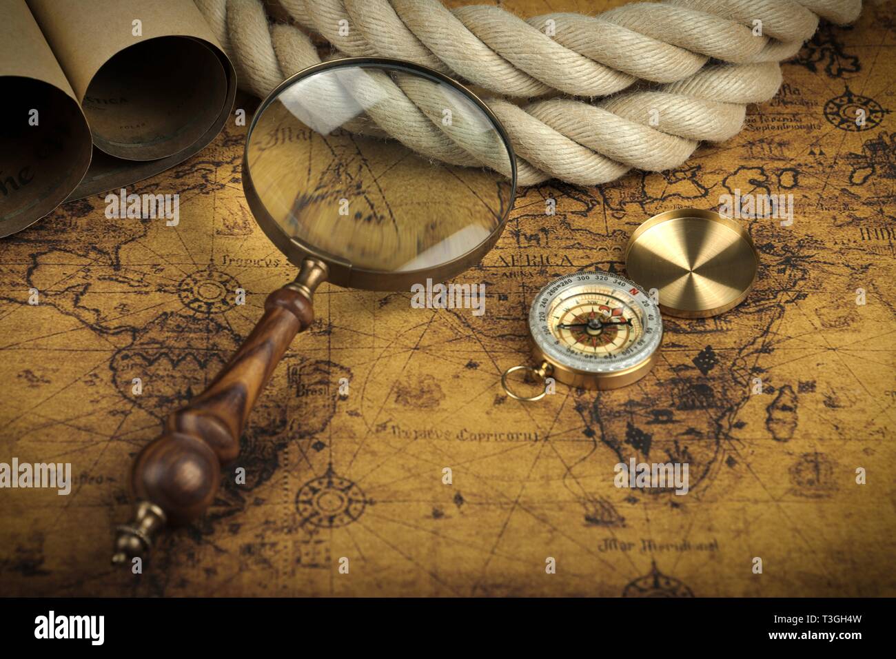 Vintage Compass and magnifying glass lies on an ancient world map ...