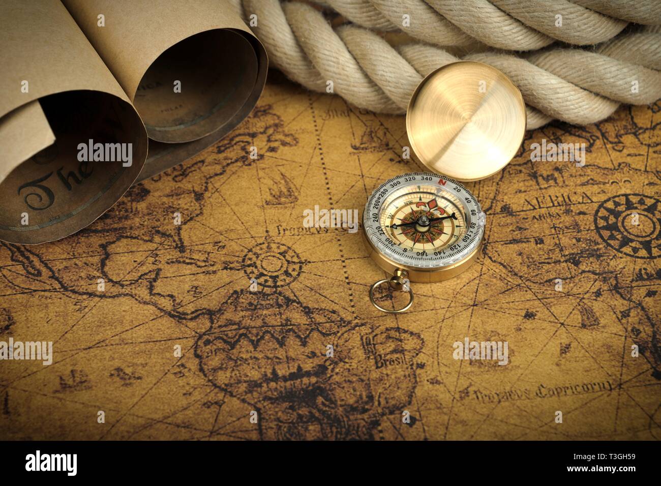 Vintage Compass lies on an ancient world map - adventure stories background Stock Photo