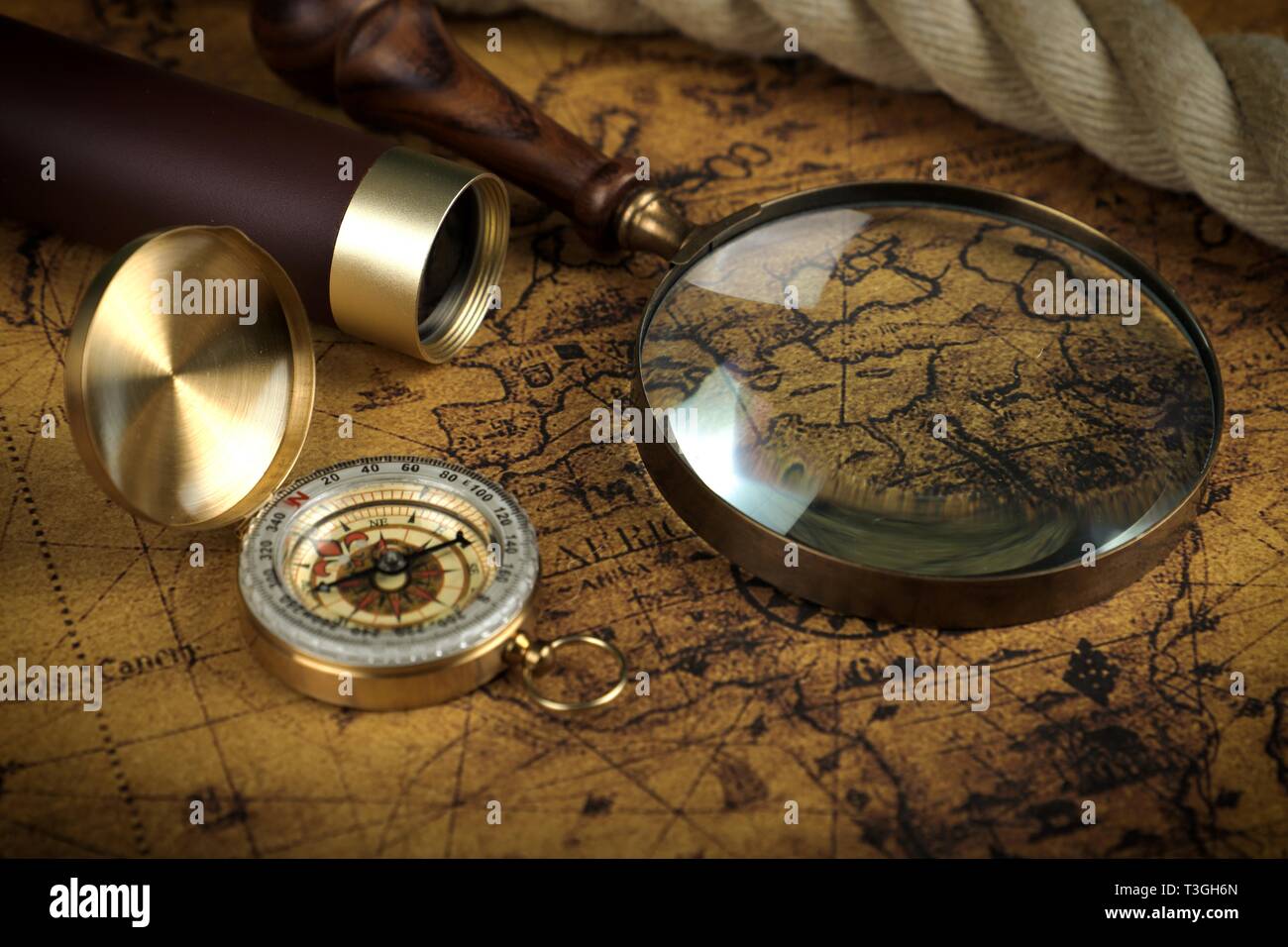 Vintage Compass and magnifying glass lies on an ancient world map ...