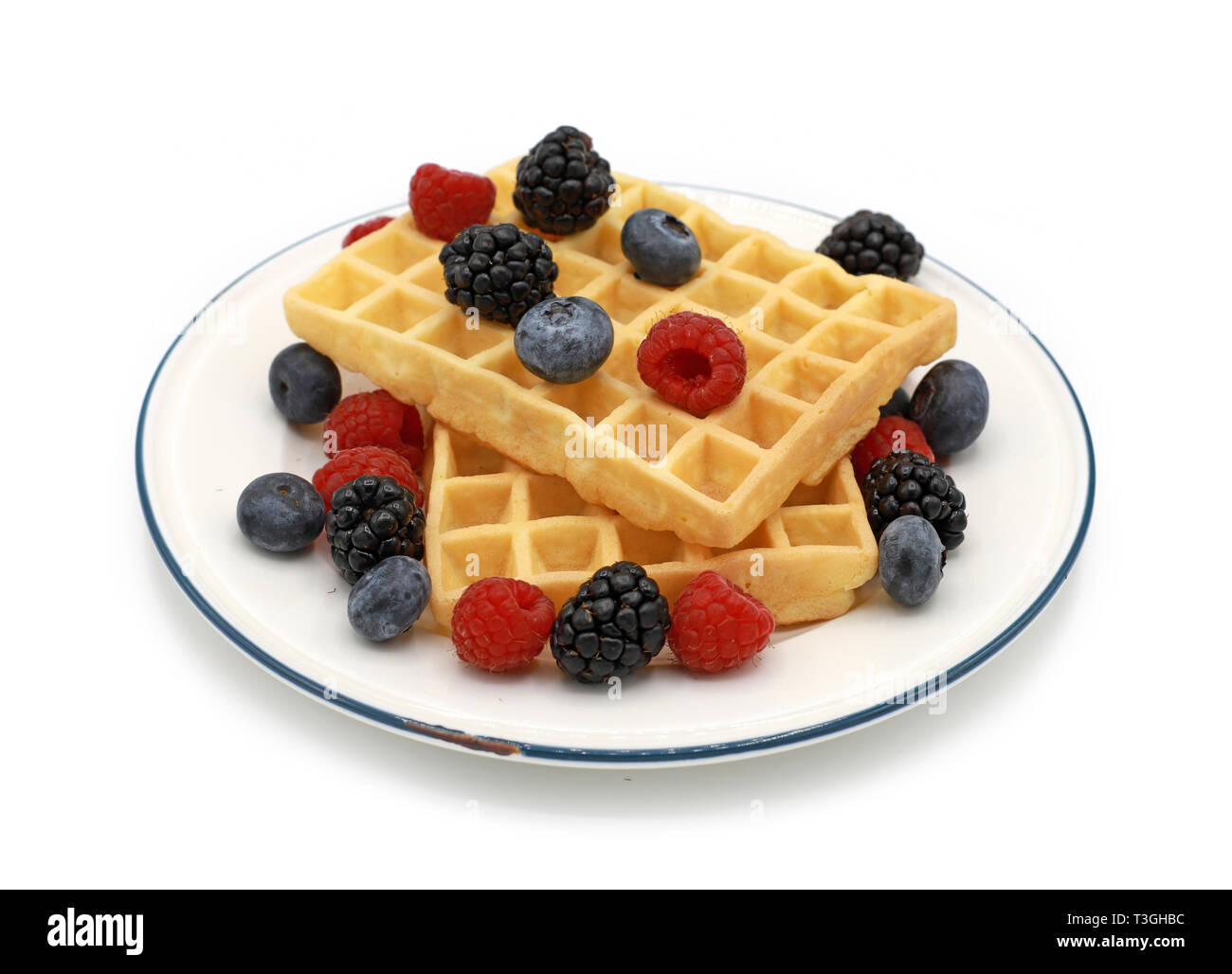 fresh belgian waffles with raspberrys and blackberries on a plate isolated on white background Stock Photo