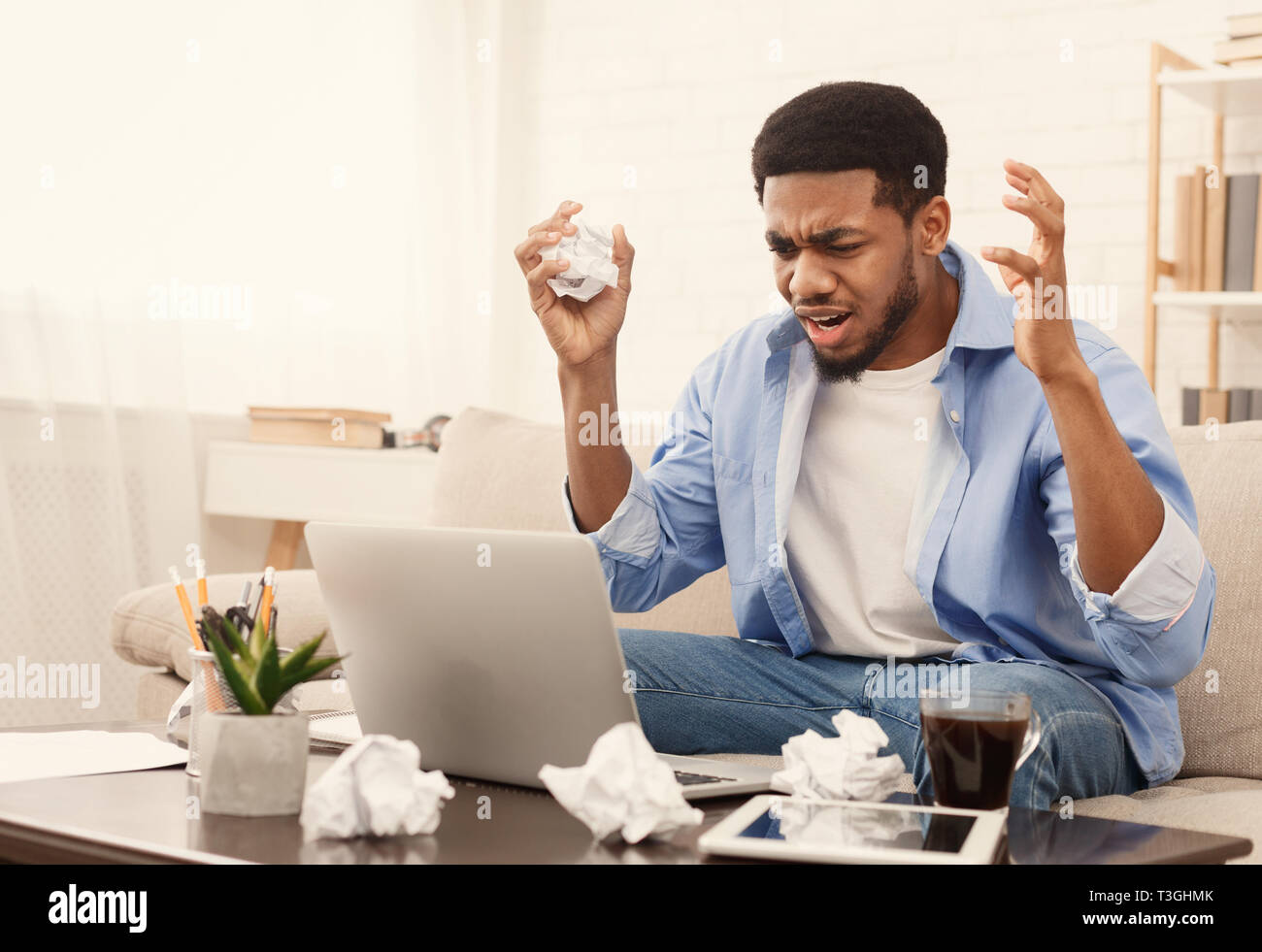 Tired african-american man working at home, copy space Stock Photo