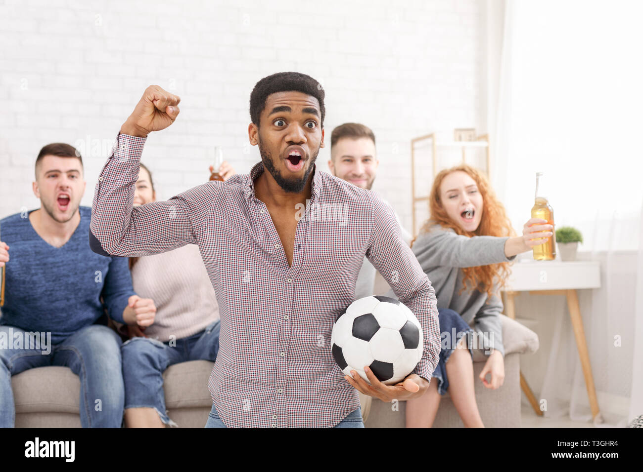 Goal. Excited friends watching football match at home Stock Photo