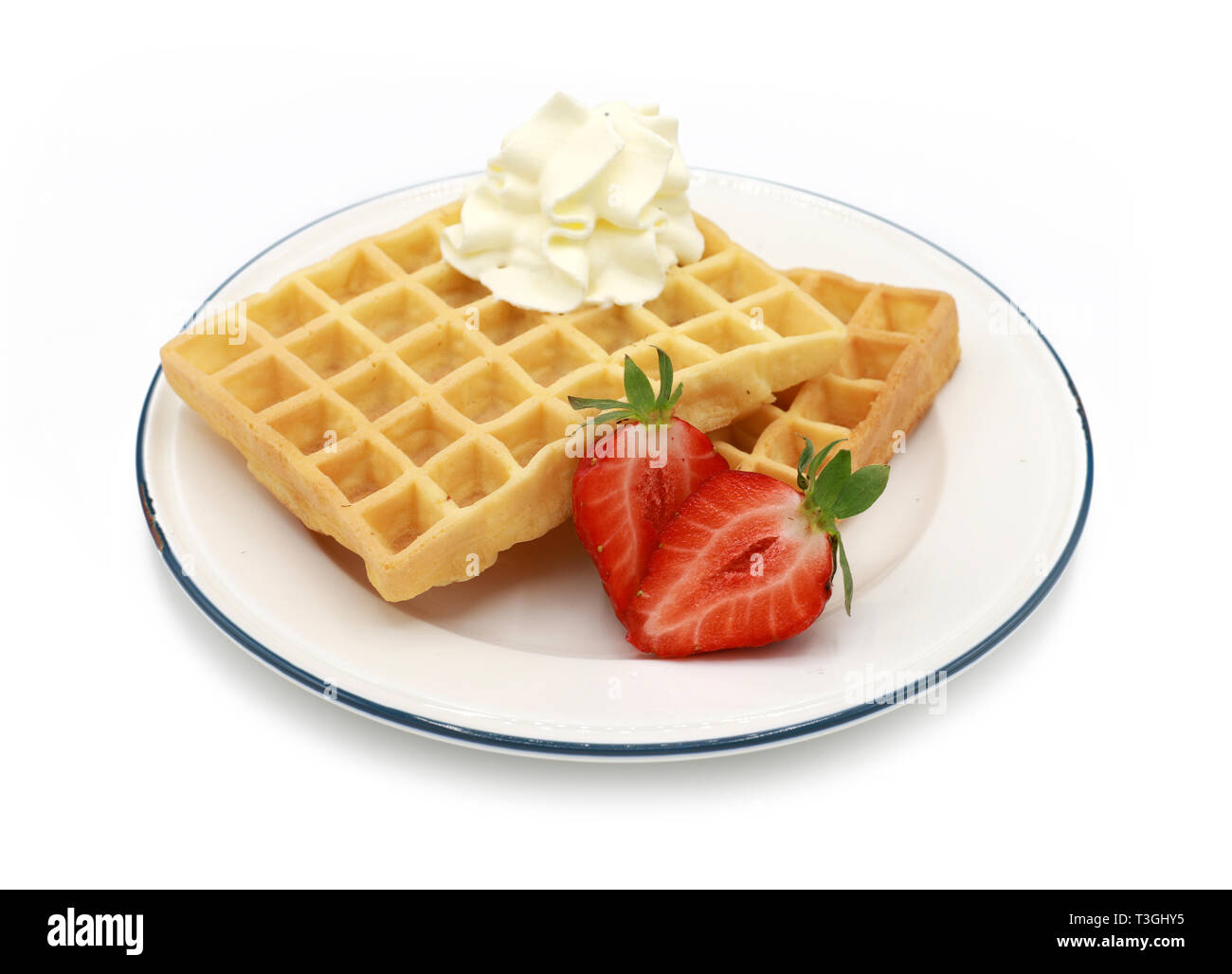 fresh belgian waffles topped strawberries and whipped cream on a plate ...