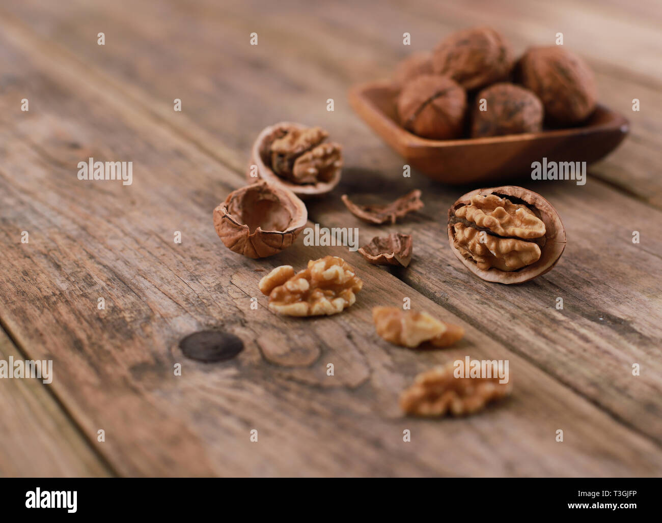 walnuts on a rustic wooden table - close up - walnuts broken up and closed Stock Photo