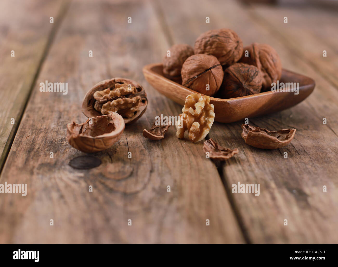 walnuts on a rustic wooden table - close up - walnuts broken up and closed Stock Photo