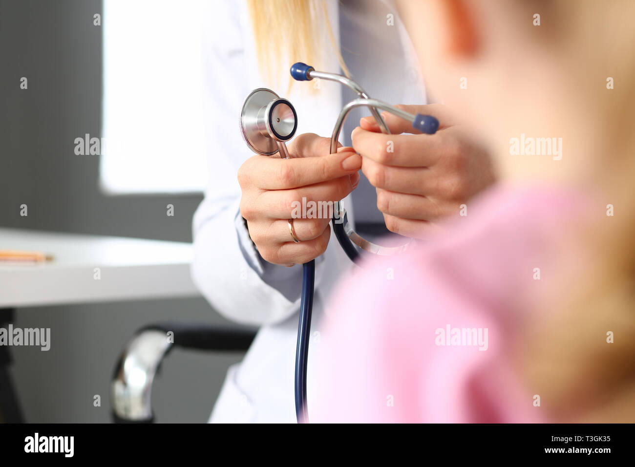 Female doctor arm hold stethoscope measuring patient heartbeat Stock