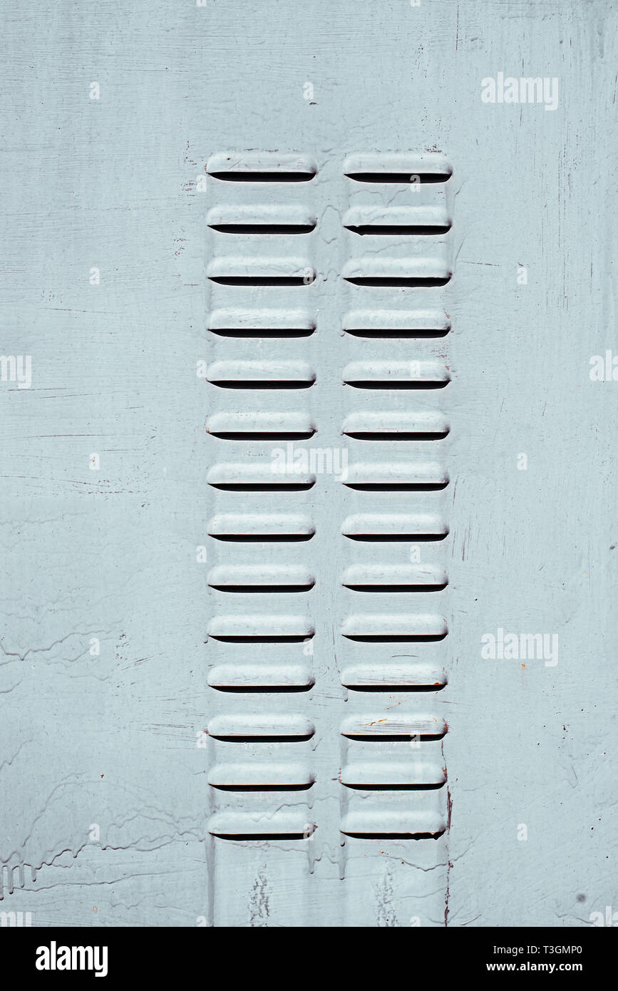 Two rows of perforated air vents on steel door in switchboard. Stock Photo
