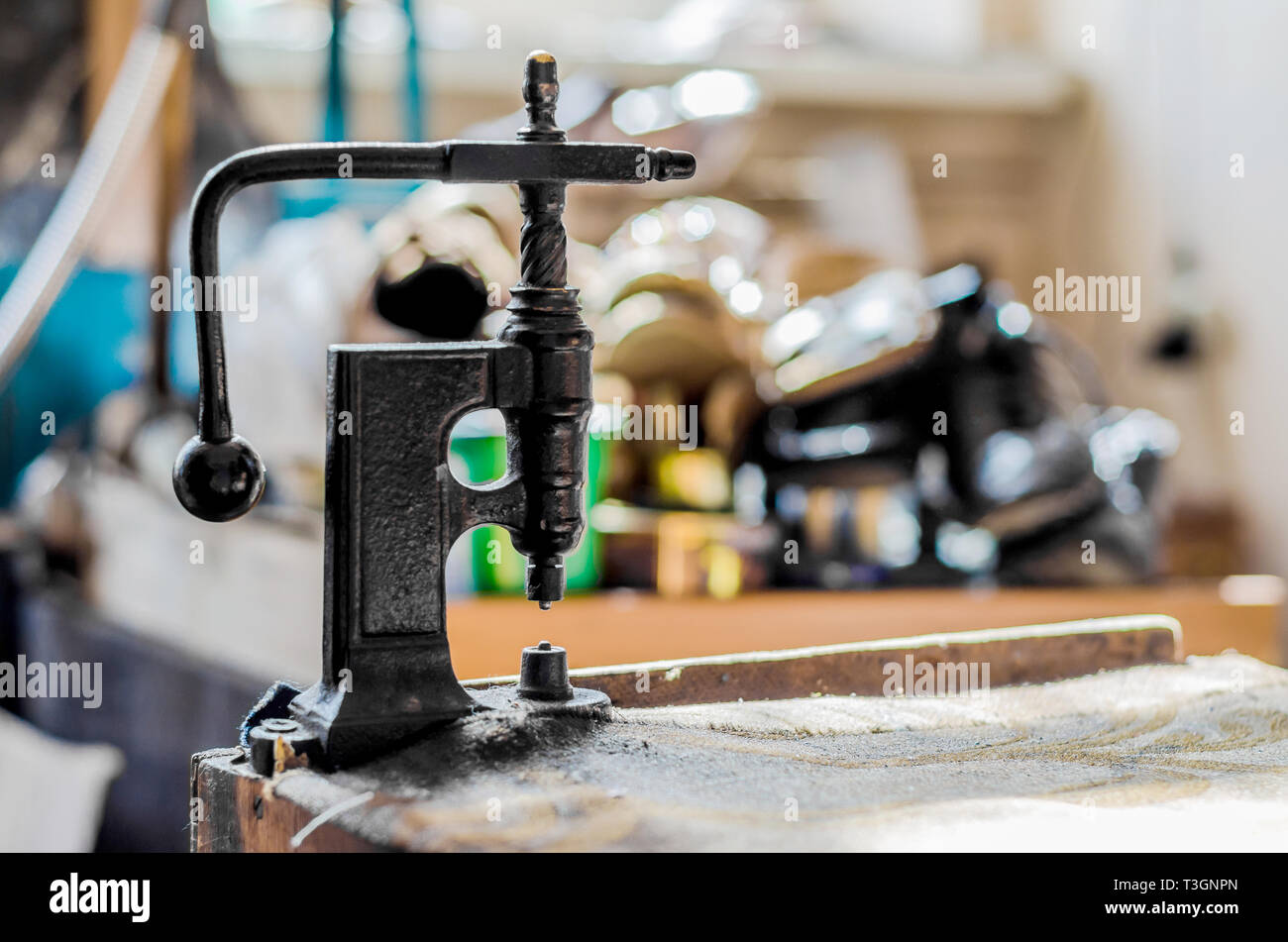 Vintage hand-press for setting rivets on clothes. The shoemaker's workshop. Stock Photo