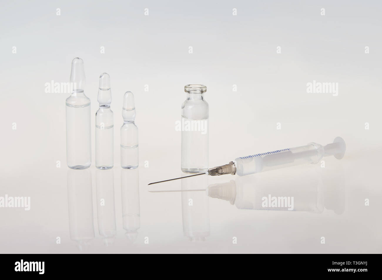 Medical vials for injection with a syringe and ampules on gray