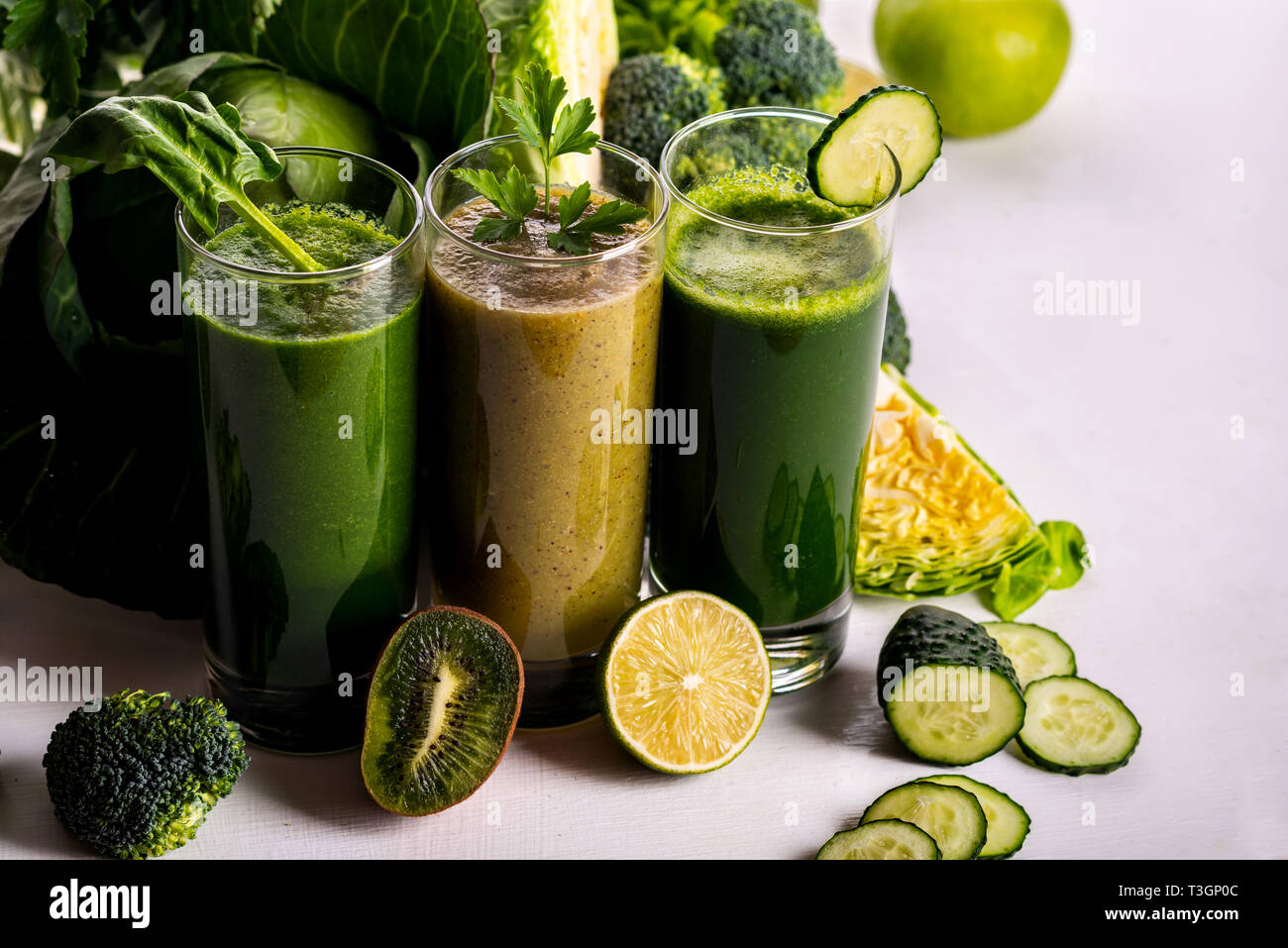 Different healthy vegan spinach kiwi and cucumber drinks on the white Different healthy vegan spinach kiwi and cucumber drinks on the white