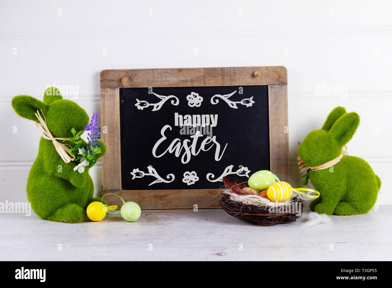 Easter scene with colored eggs in nest and two green rabbits with happy ...