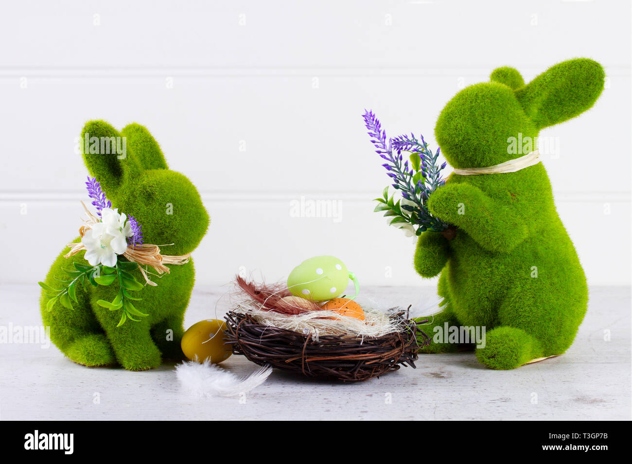 Easter scene with colored eggs in nest and two green bunnies, eggs hunt ...