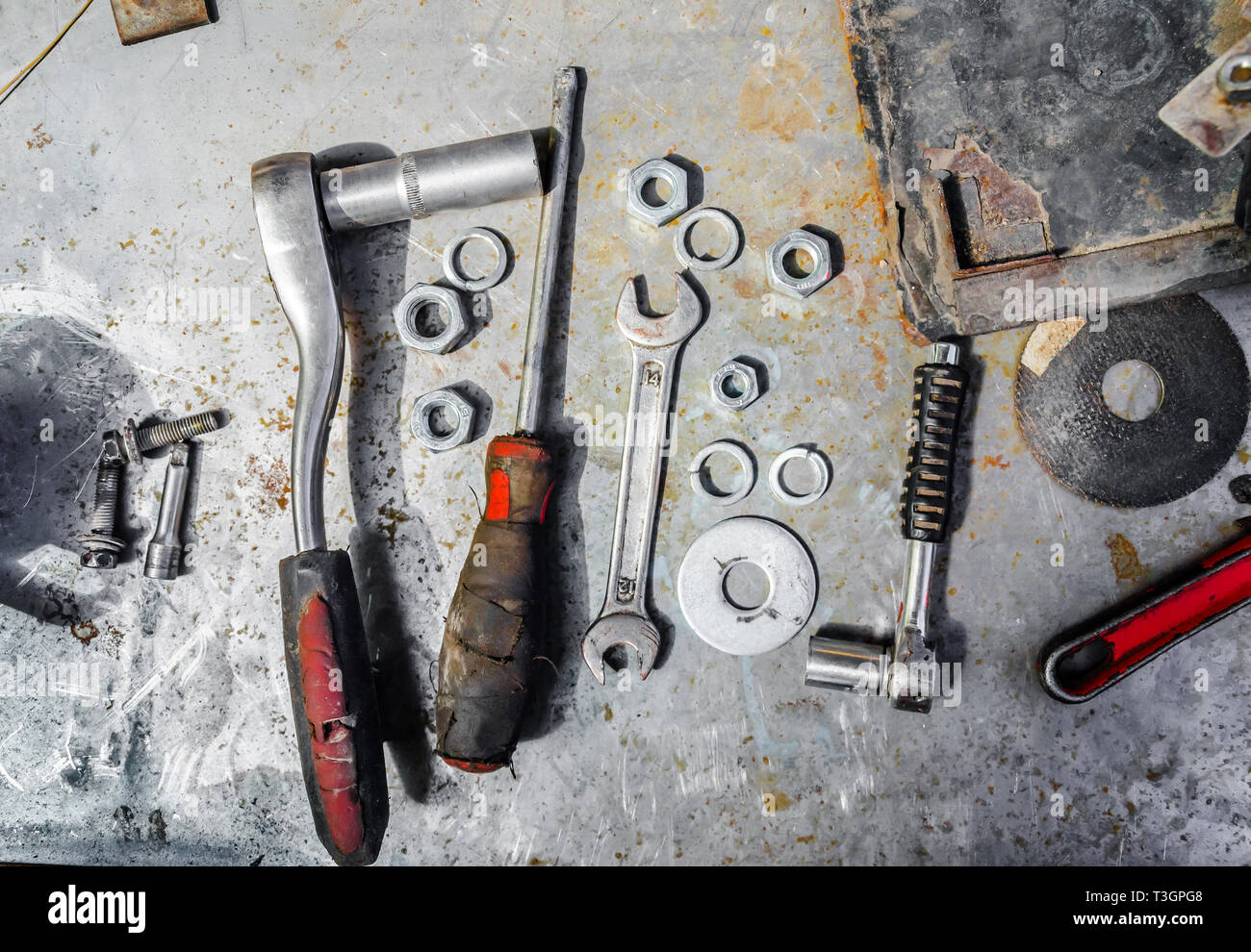Old tools, wrenches, screwdriver, nuts, lie on a metal table, workshop, repair Stock Photo