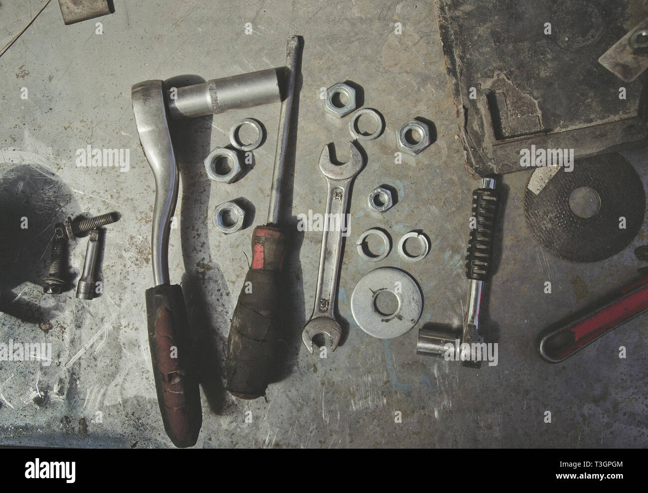 Old tools, wrenches, screwdriver, nuts, lie on a metal table, workshop, repair Stock Photo