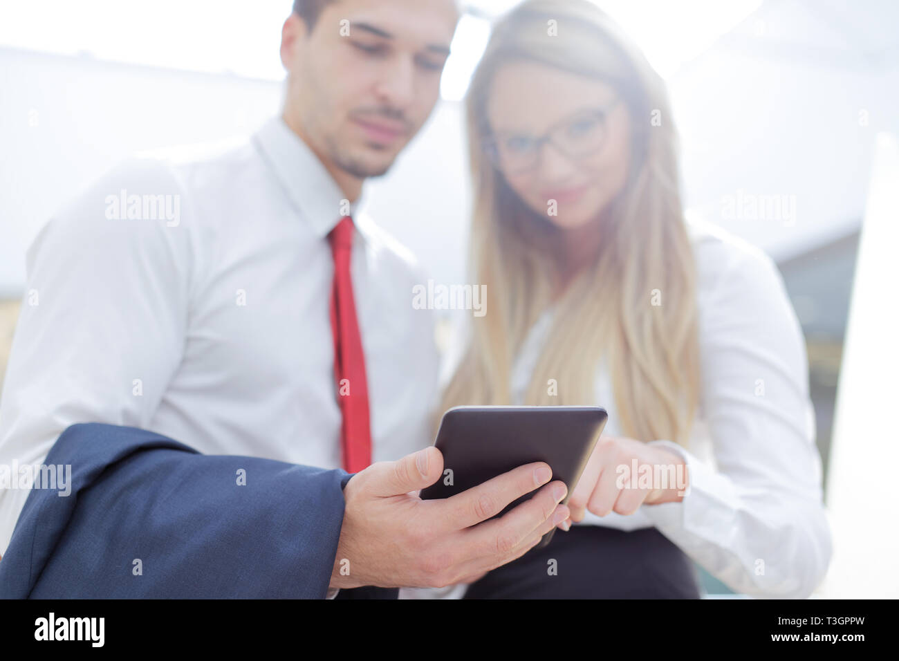 Young businesspeople using tablet in business center, depth of field Stock Photo