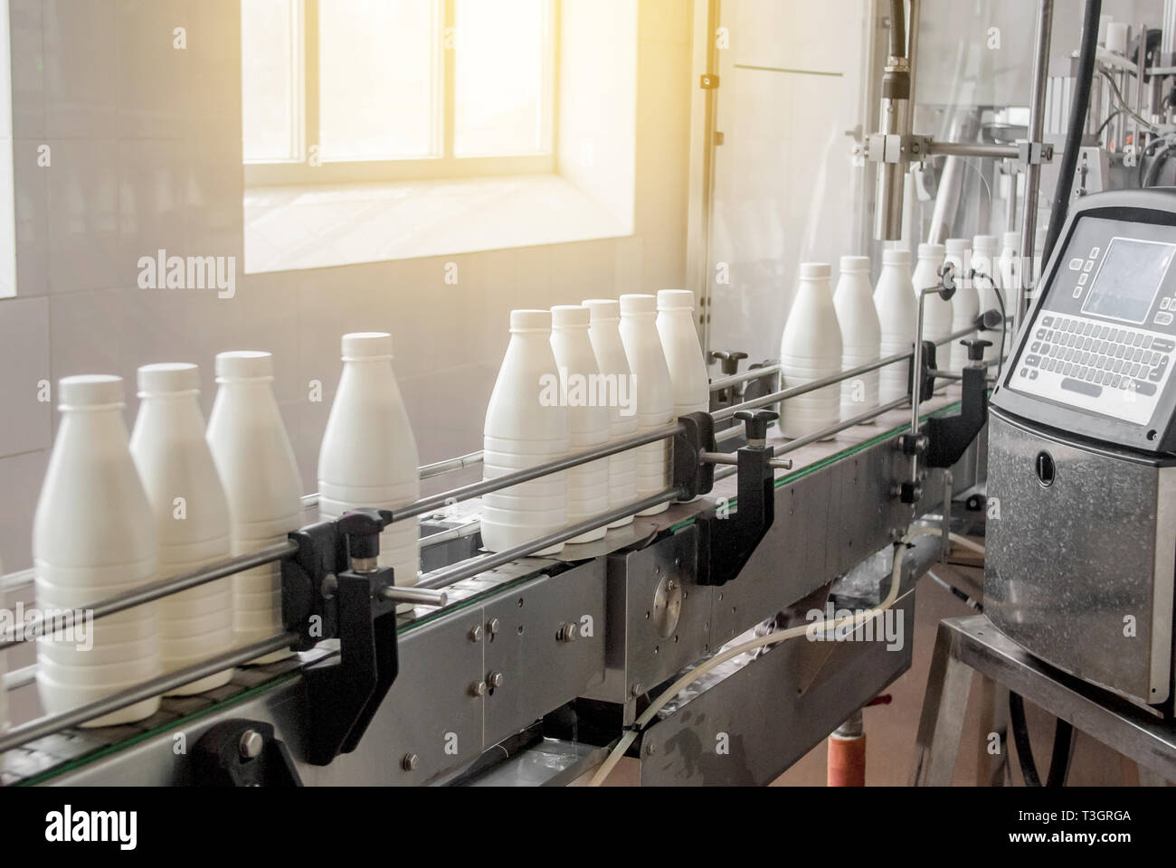 Conveyor belt with white milk bottles Stock Photo Alamy
