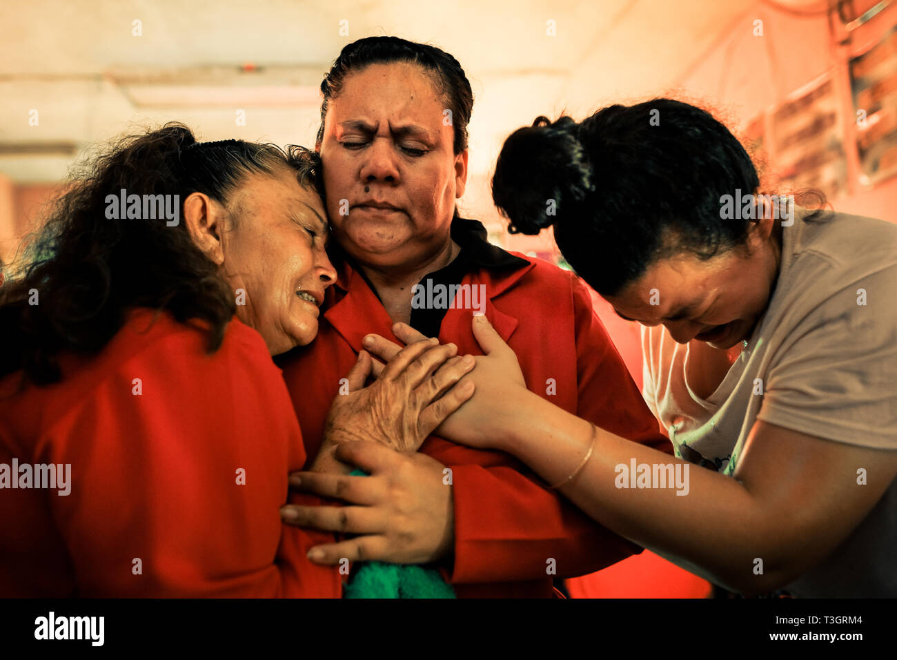 Christian followers, members of a local religious cult, cry desperately during the religious exaltation in a home church in San Salvador, El Salvador. Stock Photo