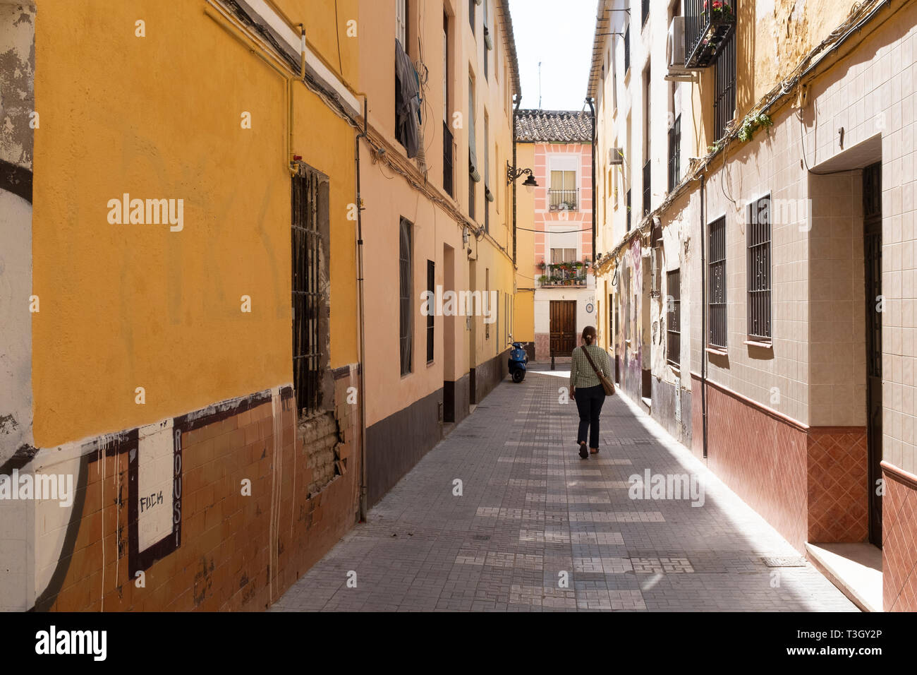 Female visitor walking alone down street in Malaga, Spain Stock Photo
