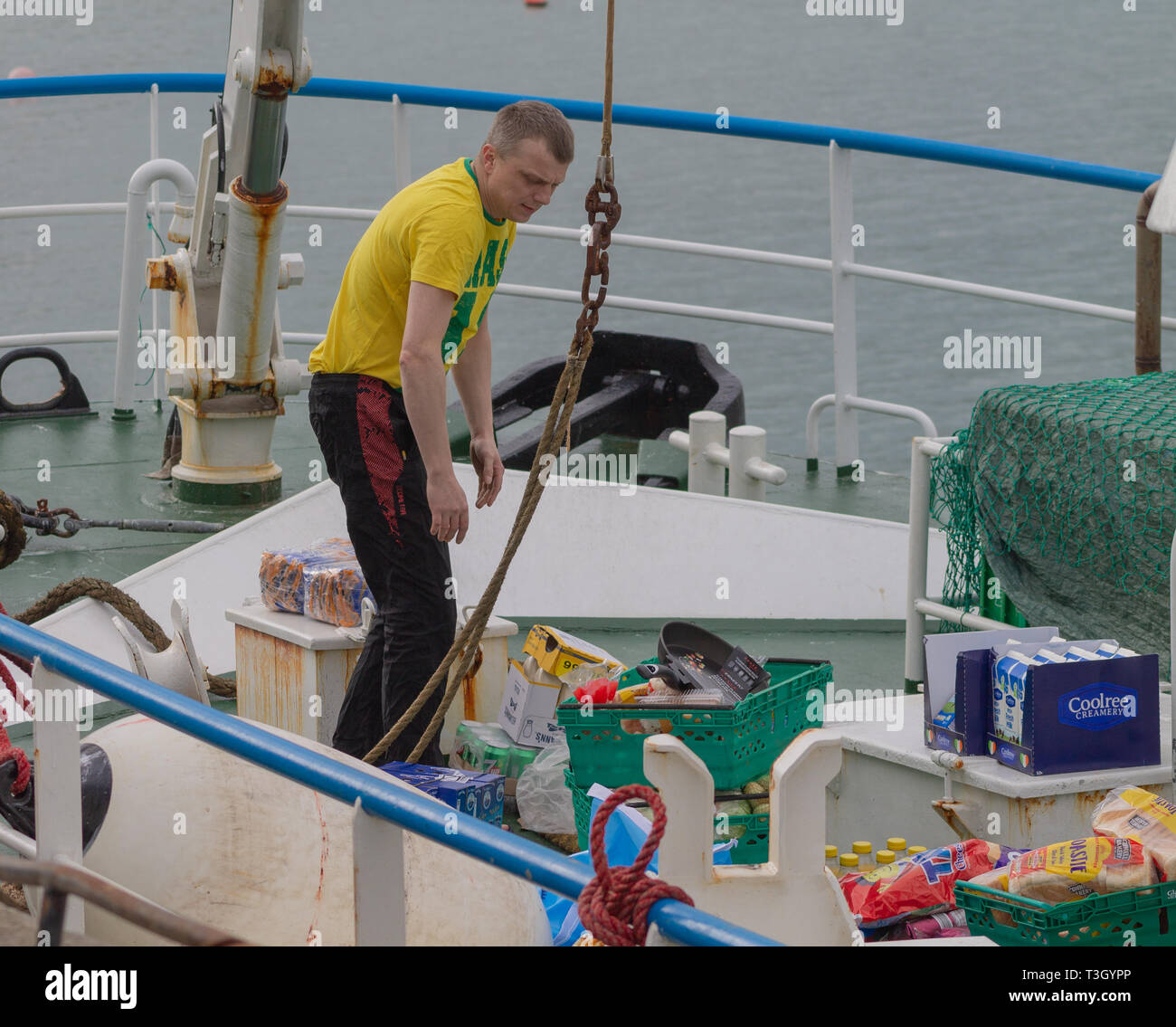 trawler crew re provisioning or restocking food storing ship. Stock Photo