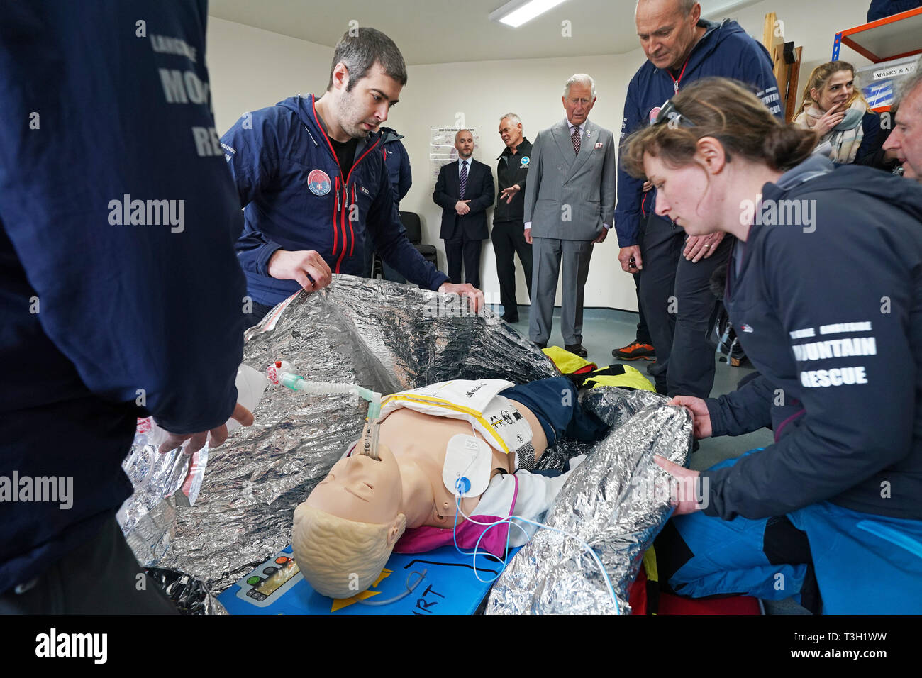 The Prince of Wales watches volunteers taking part in a training exercise during his visit to Langdale Ambleside Mountain Rescue Team while on a tour of Cumbria. Stock Photo
