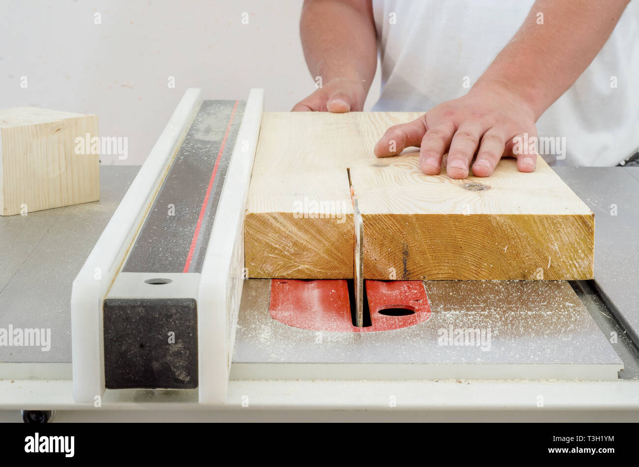 Woodworking, a man cutting a board on a circular saw machine Stock