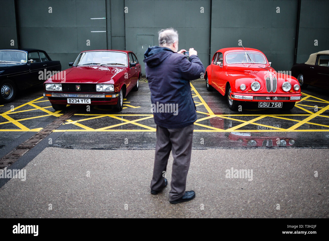 A man photographs classic Bristol cars as a vintage Bristol vehicle rally prepares to drive from Aerospace Bristol to the Fleet Air Arm Museum in Yeovilton, Somerset, where the Bristol Aeroplane Company produced Bristol Cars. Stock Photo