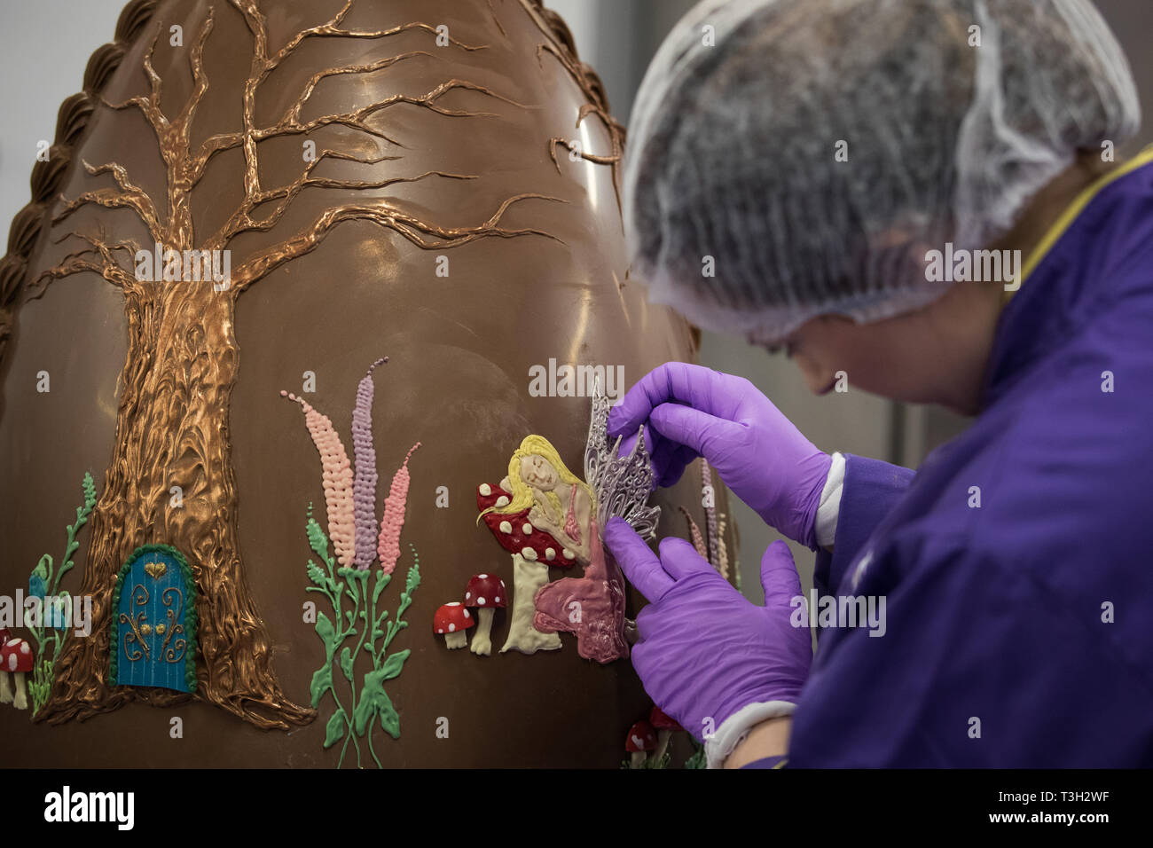 Chocolatiers decorate a giant chocolate egg at Cadbury World in Birmingham to celebrate Easter. Stock Photo