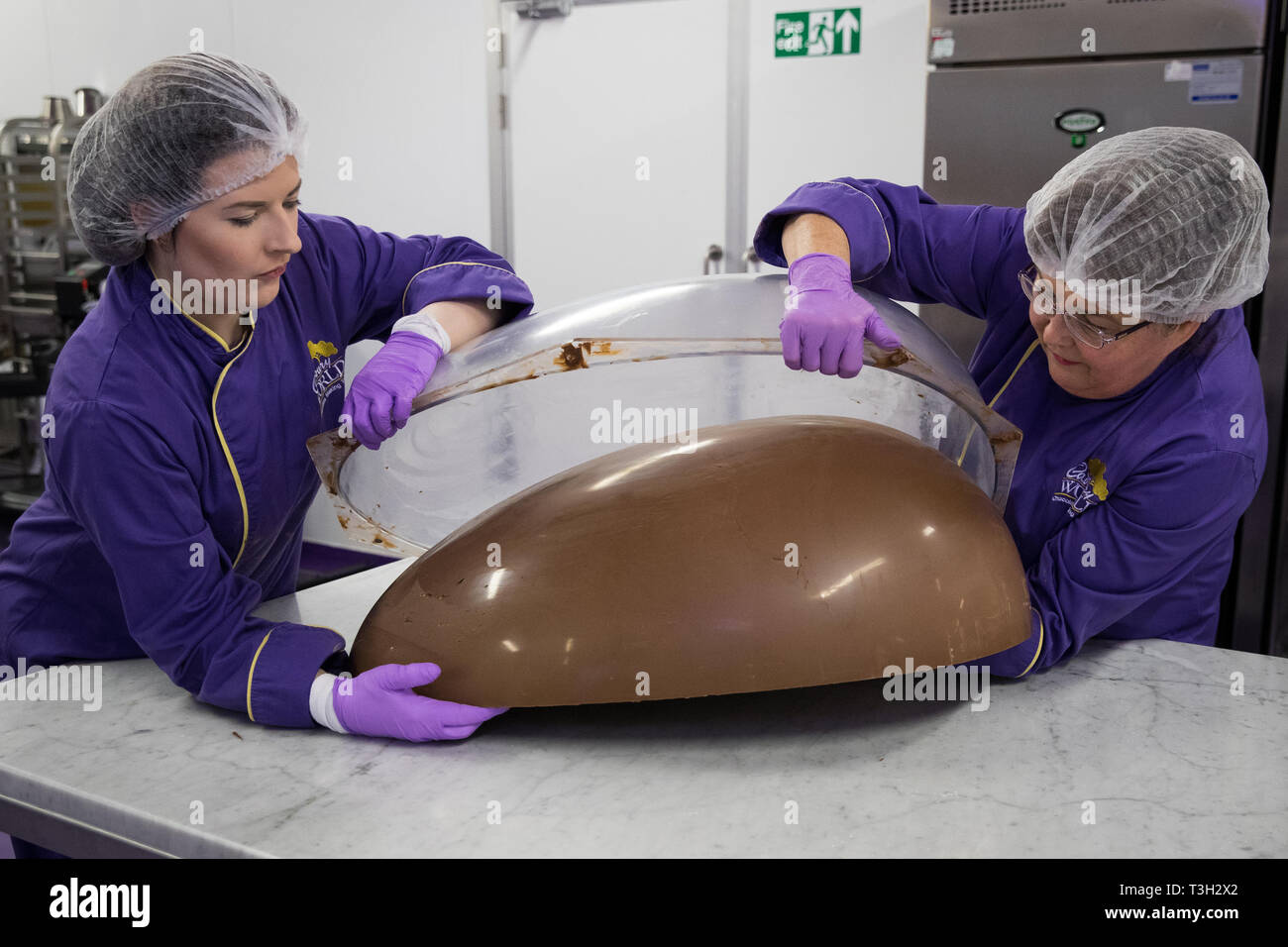 Chocolatiers cast half a giant chocolate egg at Cadbury World in Birmingham that they are making to celebrate Easter. Stock Photo