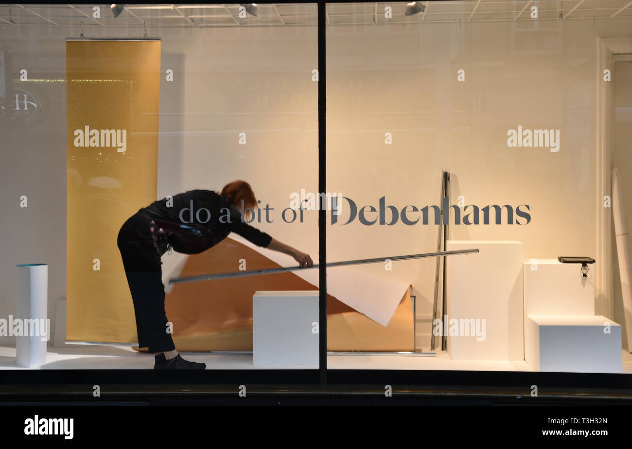 A Window Dresser At Work In The Bristol Branch Of Debenhams After