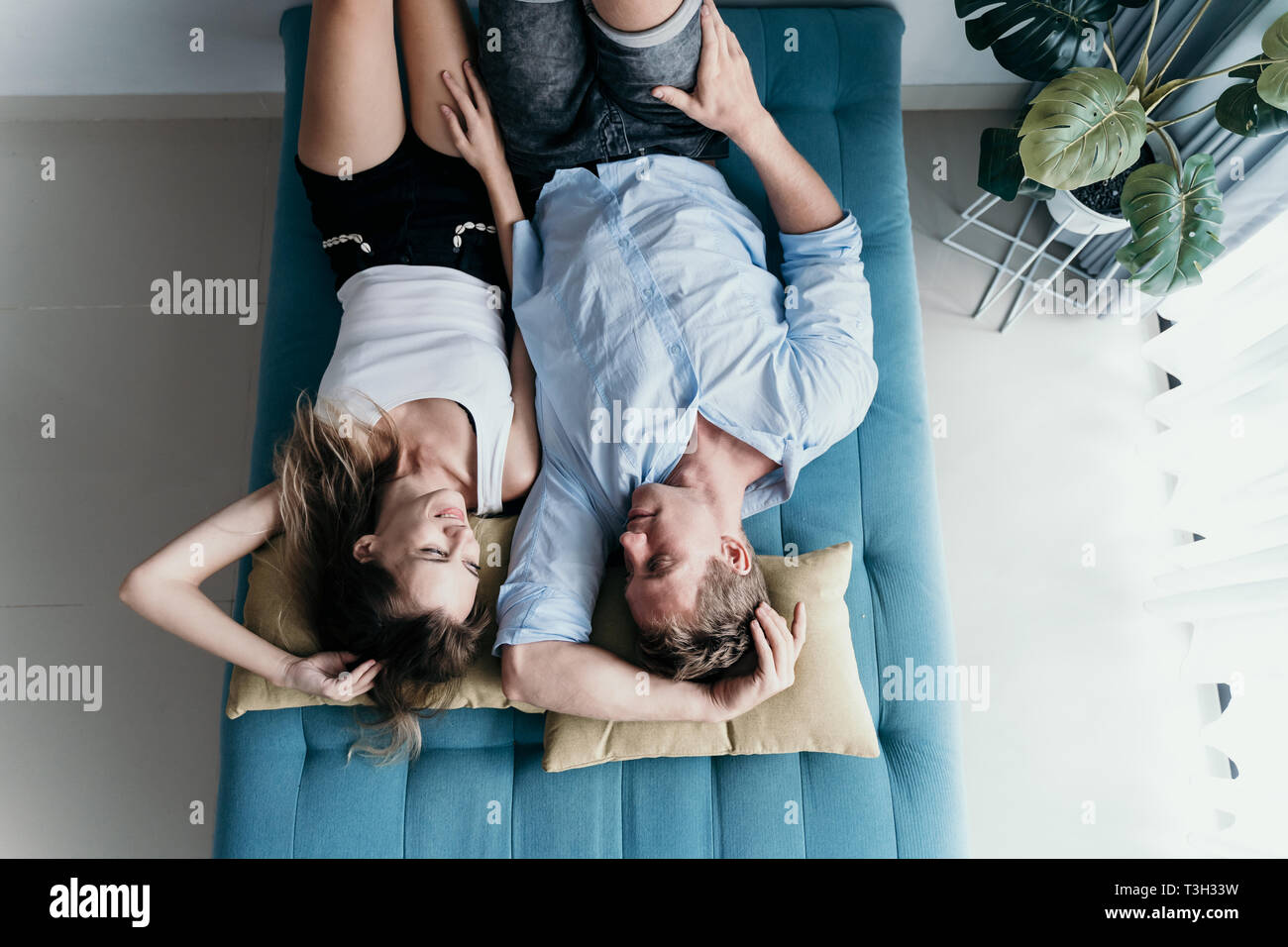 couple talking each other while lying on bed Stock Photo